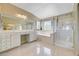 Bright bathroom with a soaking tub, glass-enclosed shower, and dual vanities at 2726 Manteno Ct, Henderson, NV 89052