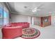 Bonus room with red sofa, round rug, and staircase at 2726 Manteno Ct, Henderson, NV 89052