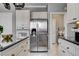 Bright kitchen featuring stainless steel refrigerator, white cabinetry, and black countertops at 2726 Manteno Ct, Henderson, NV 89052