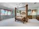 Spacious main bedroom with a four-poster bed, sitting bench, and large windows at 2726 Manteno Ct, Henderson, NV 89052