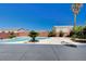 Backyard pool featuring desert landscaping, a red brick wall, palm trees and a grey patio at 2726 Manteno Ct, Henderson, NV 89052