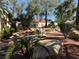 A beautifully landscaped backyard featuring mature trees, decorative rocks, and desert-friendly vegetation at 2796 Cape Hope Way, Las Vegas, NV 89121