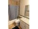 This bathroom has beige tile walls, a tub shower combo with a blue and white shower curtain and a granite countertop at 2796 Cape Hope Way, Las Vegas, NV 89121