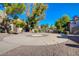 Common area with a circular concrete pad, mature landscaping, and trees, providing a welcoming outdoor space at 2966 Juniper Hills Blvd # 102, Las Vegas, NV 89142