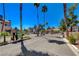 Gated community entrance with lush landscaping and mature palm trees, offering a secure and welcoming ambiance at 2966 Juniper Hills Blvd # 102, Las Vegas, NV 89142