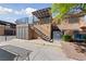 Exterior shot of a two-story condo featuring a stairway leading to an upper-level patio at 320 Shadybrook Ln # D, Las Vegas, NV 89107