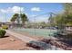 Exterior image of a fenced community tennis court surrounded by sidewalks, bushes and trees at 320 Shadybrook Ln # D, Las Vegas, NV 89107