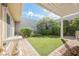 Beautiful backyard featuring a covered patio, well-maintained artificial turf, and mature landscaping at 3287 Southridge Ave, Las Vegas, NV 89121