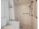 Bathroom features a shower with white tile, pebble floor and safety bars, with adjacent toilet at 3287 Southridge Ave, Las Vegas, NV 89121