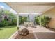 Lush backyard featuring a covered patio area with a table, desert landscaping and green artificial turf at 3287 Southridge Ave, Las Vegas, NV 89121