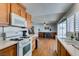 Bright kitchen featuring wood cabinets, white appliances, and an open floor plan with dining area at 4121 Satinwood Dr, Las Vegas, NV 89147