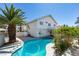 Backyard with a refreshing pool, mature palm trees, and a two-story house at 4121 Satinwood Dr, Las Vegas, NV 89147