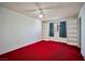 Bedroom featuring red carpet, built-in shelving, and window with privacy curtains at 416 Wyoming St, Boulder City, NV 89005