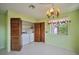 Well-lit dining area with tile flooring, window, laundry closet and decorative chandelier at 416 Wyoming St, Boulder City, NV 89005