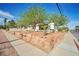 Charming single-story home with a well-maintained front yard, mature trees, rock detail and landscaping at 416 Wyoming St, Boulder City, NV 89005