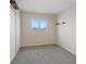 A bright, empty bedroom with neutral walls, carpet flooring, a window with a view and a large closet at 429 Sunburst Dr, Henderson, NV 89002