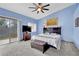 Comfortable bedroom with a sliding glass door, ceiling fan, and relaxing light-blue painted walls at 4322 Summers Shade St, Las Vegas, NV 89147