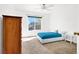 Bright bedroom features a large window, plush carpet, ceiling fan, and a cozy bed with blue bedding at 4555 E Sahara Ave # 120, Las Vegas, NV 89104