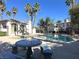 Community pool area with clear blue water, mature palm trees, and comfortable seating and tables at 4555 E Sahara Ave # 120, Las Vegas, NV 89104