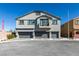 Modern townhome with three garage bays, gray paint and a small balcony at 4790 Equinox Sky Ave # 2, North Las Vegas, NV 89084
