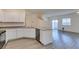 Open kitchen and living room with white cabinets and stainless steel appliances at 4790 Equinox Sky Ave # 2, North Las Vegas, NV 89084