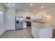 Open kitchen with stainless appliances, white cabinets, breakfast bar and wood-look floors at 4790 Equinox Sky Ave # 2, North Las Vegas, NV 89084