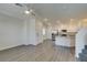 Open living space flowing into a modern kitchen with wood-look floors, a ceiling fan, and natural light at 4790 Equinox Sky Ave # 2, North Las Vegas, NV 89084