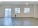 Well-lit living room with wood-look flooring and a sliding door to a fenced outdoor space at 4790 Equinox Sky Ave # 2, North Las Vegas, NV 89084