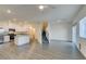 Living space with wood-look floors connects to a kitchen and staircase, filled with natural light at 4790 Equinox Sky Ave # 2, North Las Vegas, NV 89084