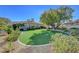 Beautifully landscaped backyard with artificial turf and mature trees at 4936 Mountain Foliage Dr, Las Vegas, NV 89148