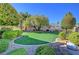 Beautifully landscaped backyard with artificial turf and mature trees at 4936 Mountain Foliage Dr, Las Vegas, NV 89148