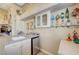 Chic home bar with granite countertop, glass shelving, and mini fridge, perfect for entertaining guests in style at 4936 Mountain Foliage Dr, Las Vegas, NV 89148