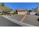 Exterior of a home with a terracotta roof and large paved driveway with a gated side entrance at 4936 Mountain Foliage Dr, Las Vegas, NV 89148