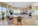 A large kitchen with a granite countertop island has breakfast bar seating under decorative overhead lighting at 4936 Mountain Foliage Dr, Las Vegas, NV 89148