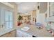 A modern kitchen with granite counters and views into the living area and a white shuttered window at 4936 Mountain Foliage Dr, Las Vegas, NV 89148