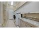 Laundry room featuring modern appliances, storage cabinets, and a granite countertop for added functionality at 4936 Mountain Foliage Dr, Las Vegas, NV 89148