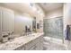 Luxurious bathroom with marble countertops, tiled shower, and ample natural light at 5640 Willow Canyon St, Las Vegas, NV 89149