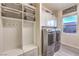 Functional laundry room with modern washer, dryer, storage cabinets, and folding area at 5640 Willow Canyon St, Las Vegas, NV 89149