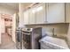 Well-equipped laundry area with stainless steel washer/dryer, sink, granite counters, and storage at 5640 Willow Canyon St, Las Vegas, NV 89149