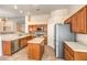 Well-lit kitchen features an island, stainless steel appliances, and wood cabinetry at 6217 Statue St, North Las Vegas, NV 89081