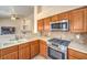 Kitchen with a stainless steel stove, microwave, and decorative tile backsplash at 6217 Statue St, North Las Vegas, NV 89081