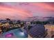 Stunning aerial view of the backyard pool and spa, showcasing city views and neighborhood at dusk at 640 Hayborn Meadows St, Las Vegas, NV 89138