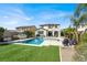 Well-manicured backyard features a pool, spa, and outdoor kitchen at 640 Hayborn Meadows St, Las Vegas, NV 89138