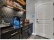 Stylish bar area with dark cabinets, patterned backsplash, wood shelves, and under cabinet lights at 640 Hayborn Meadows St, Las Vegas, NV 89138