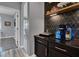 Modern bar area featuring dark wood cabinets, geometric backsplash, and floating wood shelves at 640 Hayborn Meadows St, Las Vegas, NV 89138