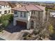 Charming two-story home with a tile roof, arched entry, and brick driveway at 640 Hayborn Meadows St, Las Vegas, NV 89138