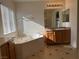 This bathroom has a large tub, a vanity with a granite-look countertop, and tile flooring at 6546 Churnet Valley Ave, Las Vegas, NV 89139