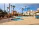 Community pool and hot tub with ample seating surrounded by palm trees at 725 Wheat Ridge Ln # 201, Las Vegas, NV 89145