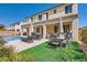 Beautiful backyard with pool, lounge chairs, outdoor dining, and a second story balcony at 7349 Merimack Oaks St, Las Vegas, NV 89166