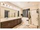 Well-lit primary bathroom featuring double sinks, a soaking tub, and a separate shower at 7349 Merimack Oaks St, Las Vegas, NV 89166